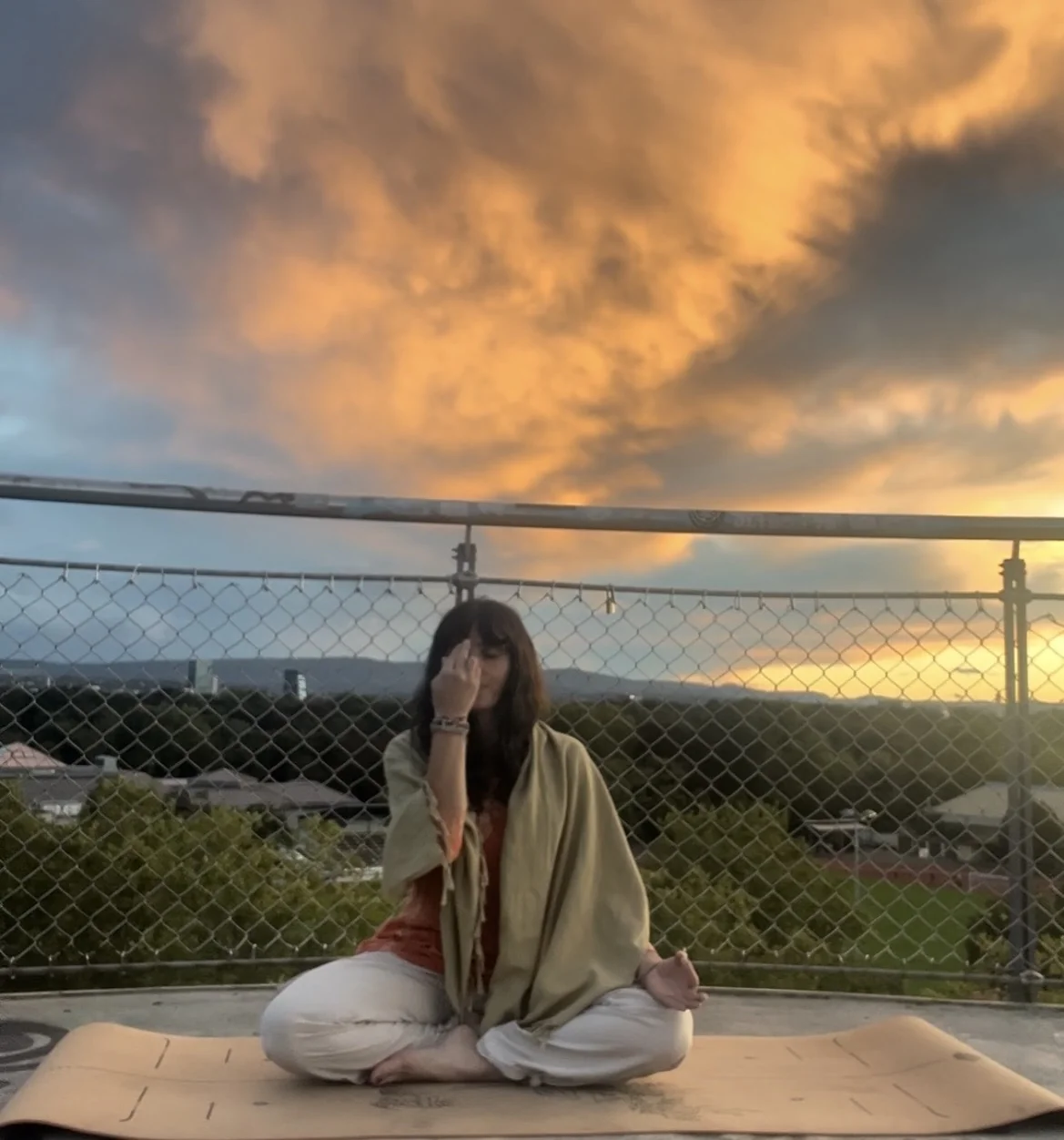 Gerta seated in meditation outdoors at sunset